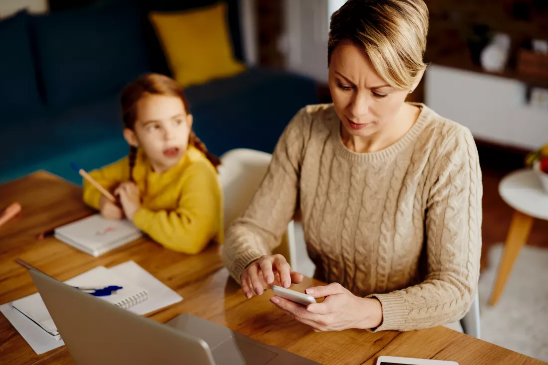 mid-adult-mother-using-smart-phone-while-working-home