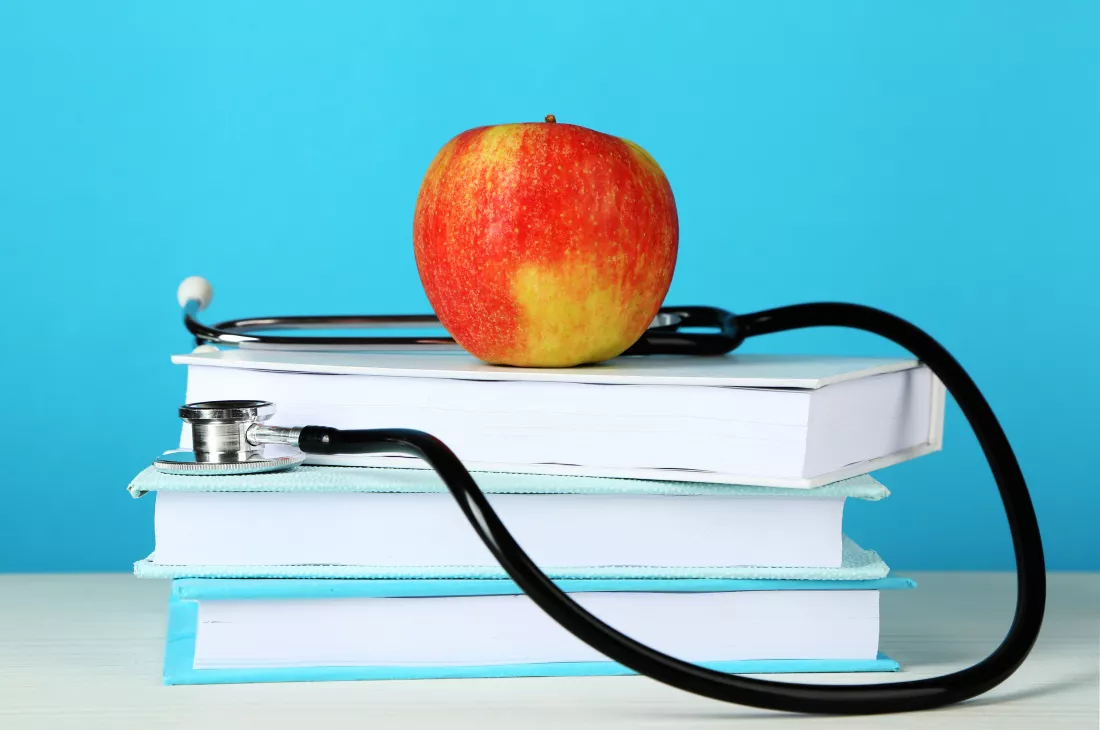 medical-stethoscope-with-apple-books-table-bright-background