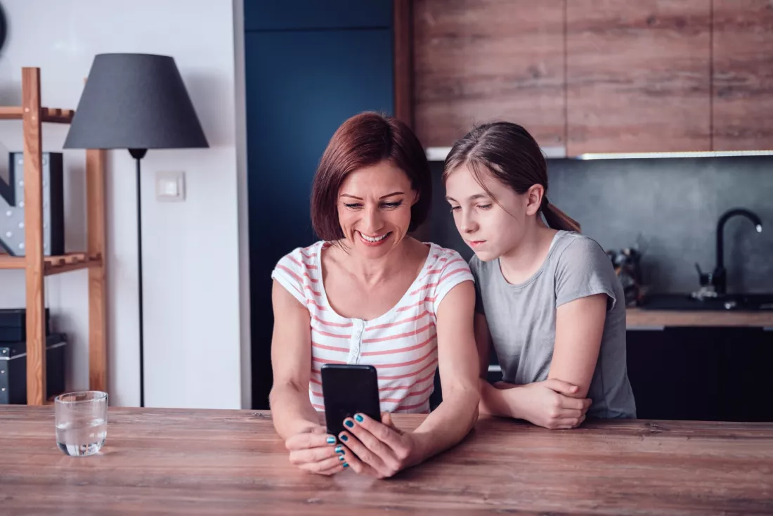 Mama i corka sprawdzaja szkolny dziennik w telefonie