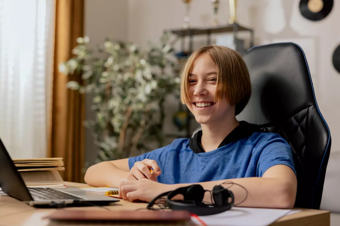 Usmiechniety maturzysta przy laptopie sprawdza wyniki