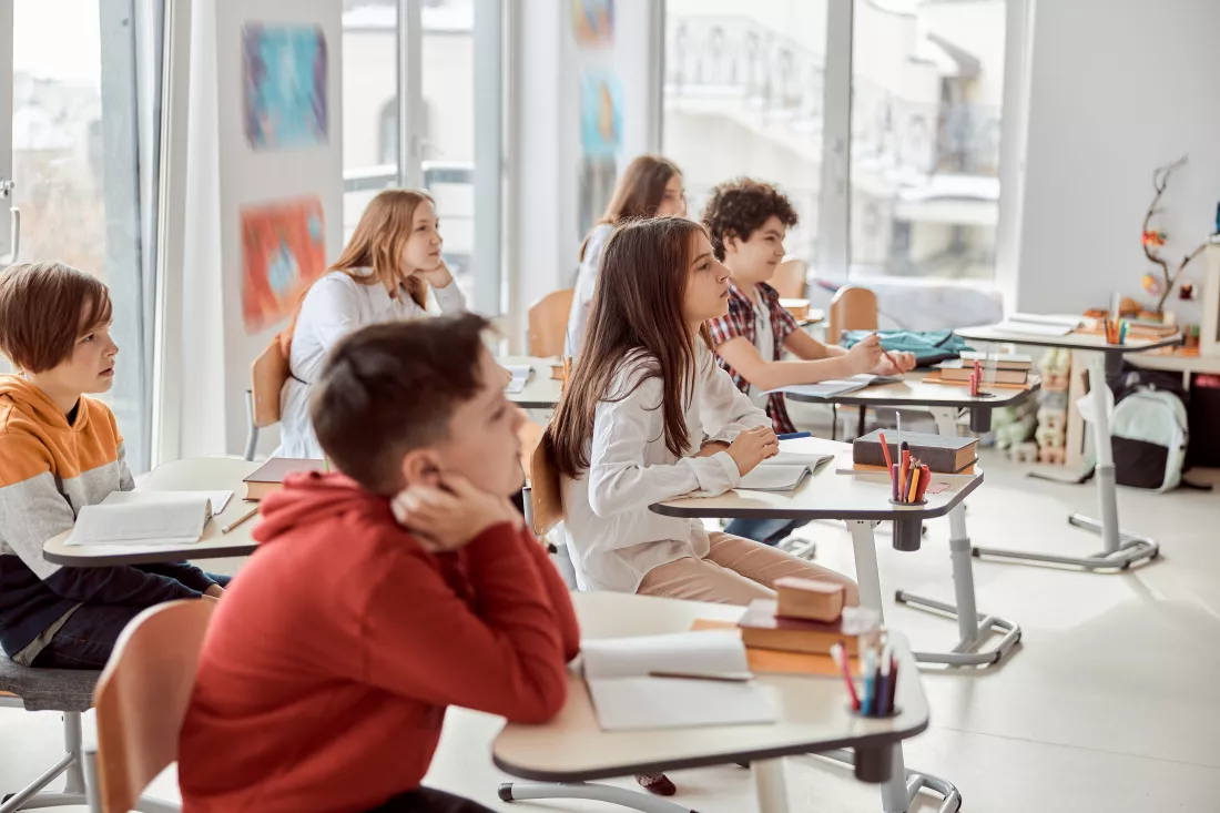 nice-pupils-are-listening-carefully-their-tutor-elementary-school-kids-sitting-desks-reading-books-classroom