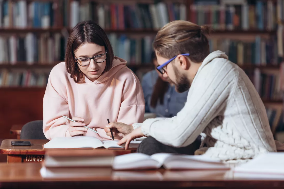 mature-man-helping-student-prepare-exams-library