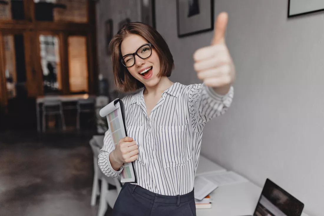 young-woman-office-style-clothes-glasses-holds-tablet-with-documents-winks-shows-thumb-up