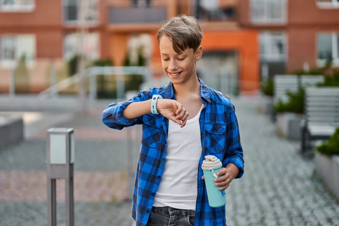 little-boy-speaking-by-blue-smartwatch-drink-tea-near-school